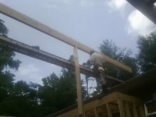 Carpenter setting a ridge beam over a new addition frame — Ice Dam Removal by Roofing Brothers in Plainfield